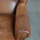 Fauteuil à oreilles de style anglais couleur cognac en cuir de vache.