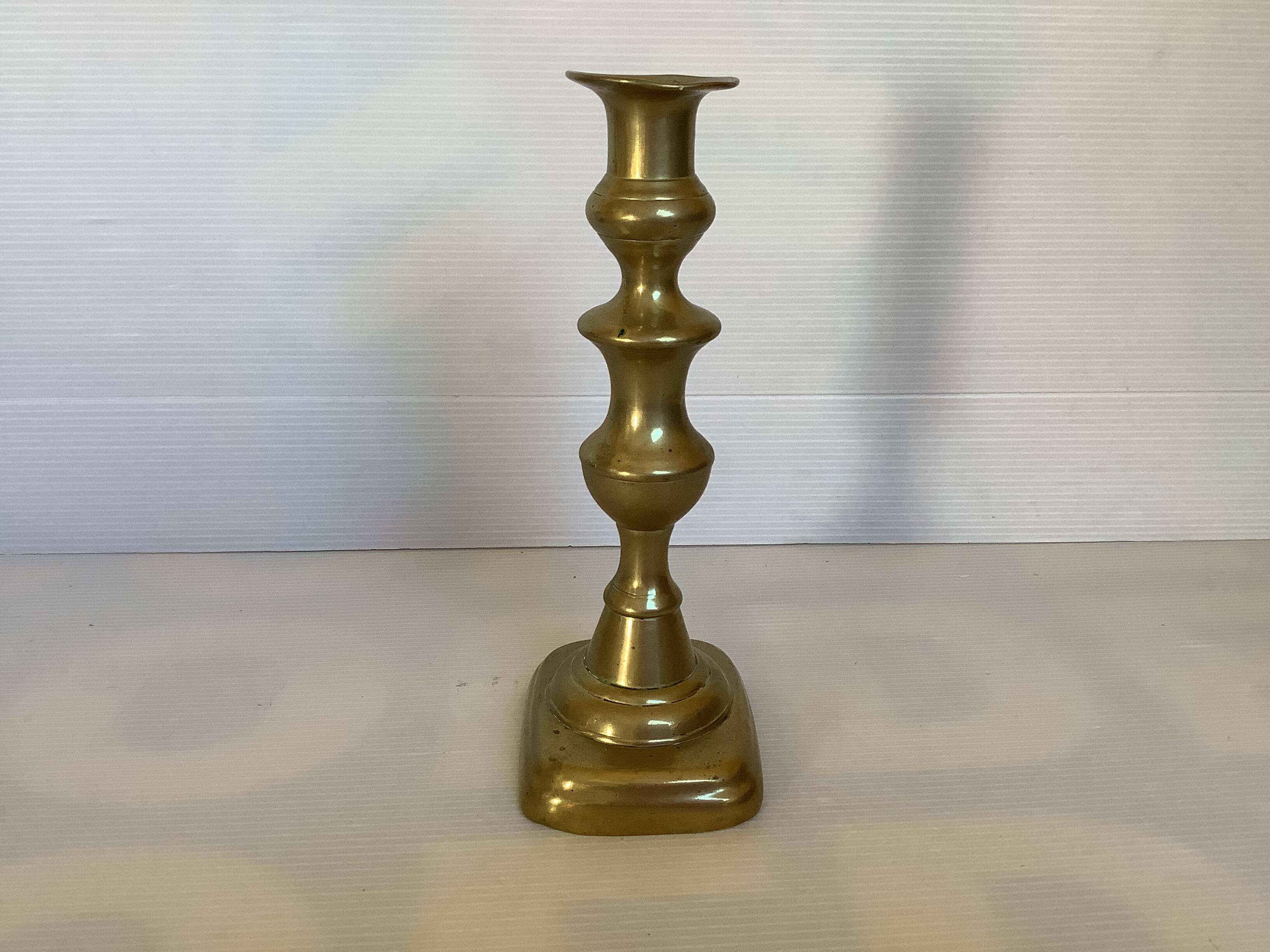 Brass candlestick with a rectangular base.