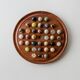 Vintage 1960s solitaire game, wooden board with stone marbles.