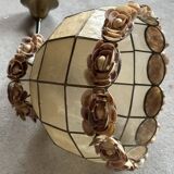 Vintage pendant light with a pearlescent shade and floral decoration.