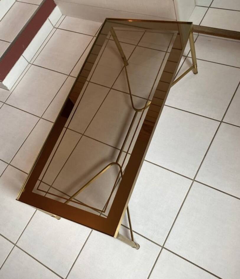 Rectangular neoclassical coffee table in gilded brass with a glass top.