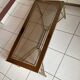Rectangular neoclassical coffee table in gilded brass with a glass top.