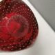 Small glass bowl in beautiful emerald red color with inlaid bubbles.