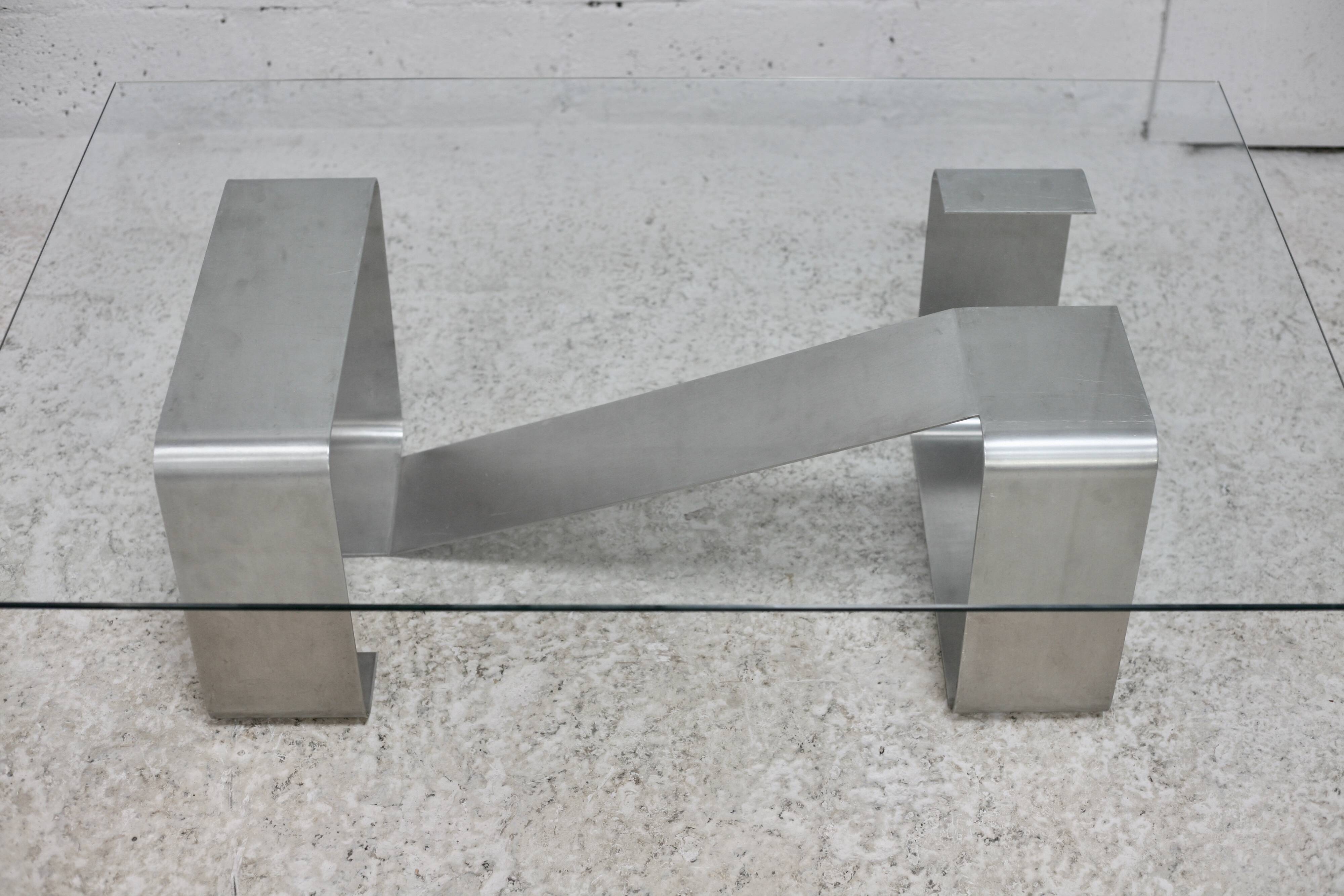 Coffee table with "kinetic" steel base and glass slab. Circa 1970.