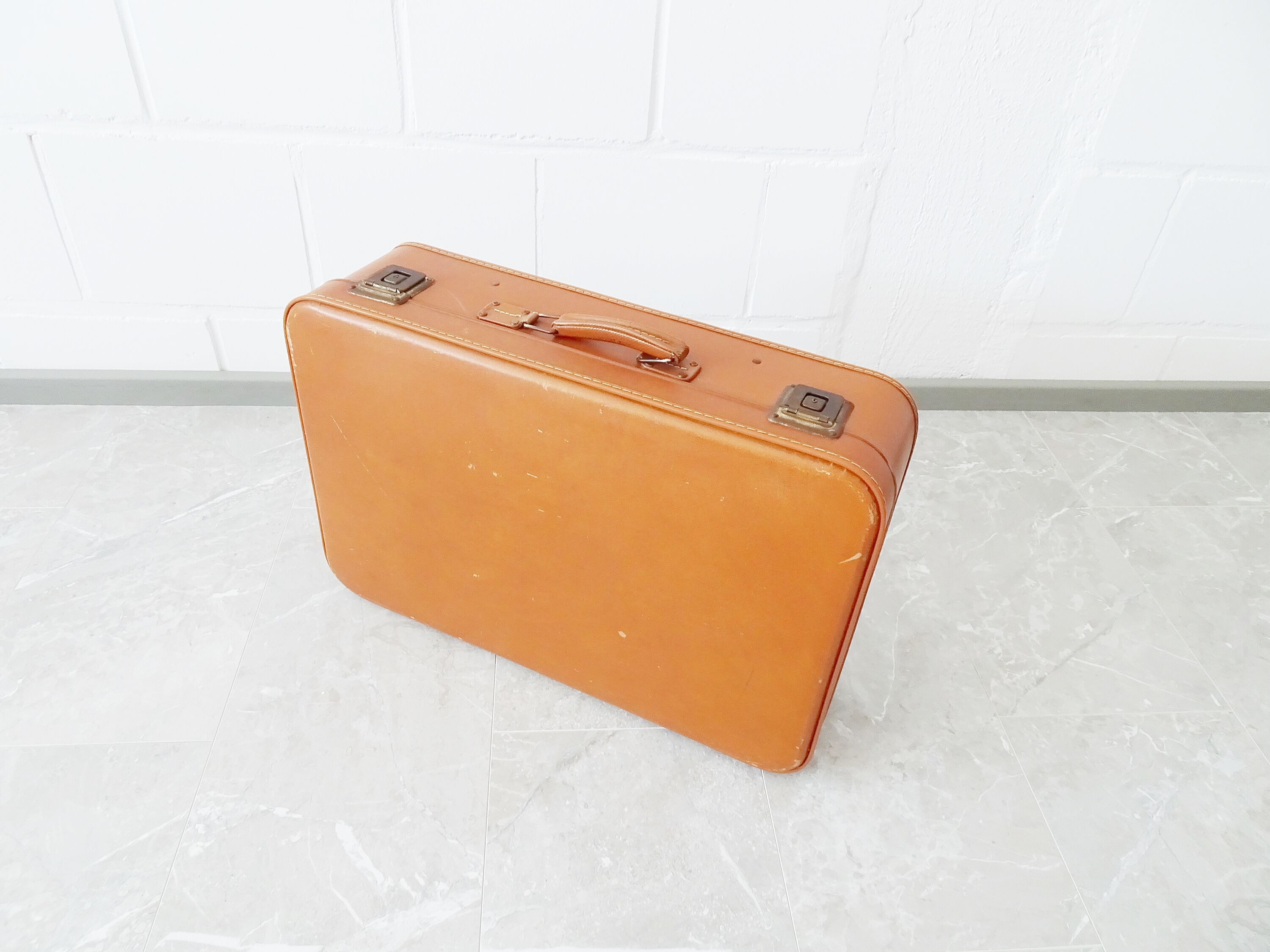 Valise de couleur cognac, valise dure