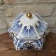 Decorative pot jar with a lid featuring a blue floral pattern and gilding.