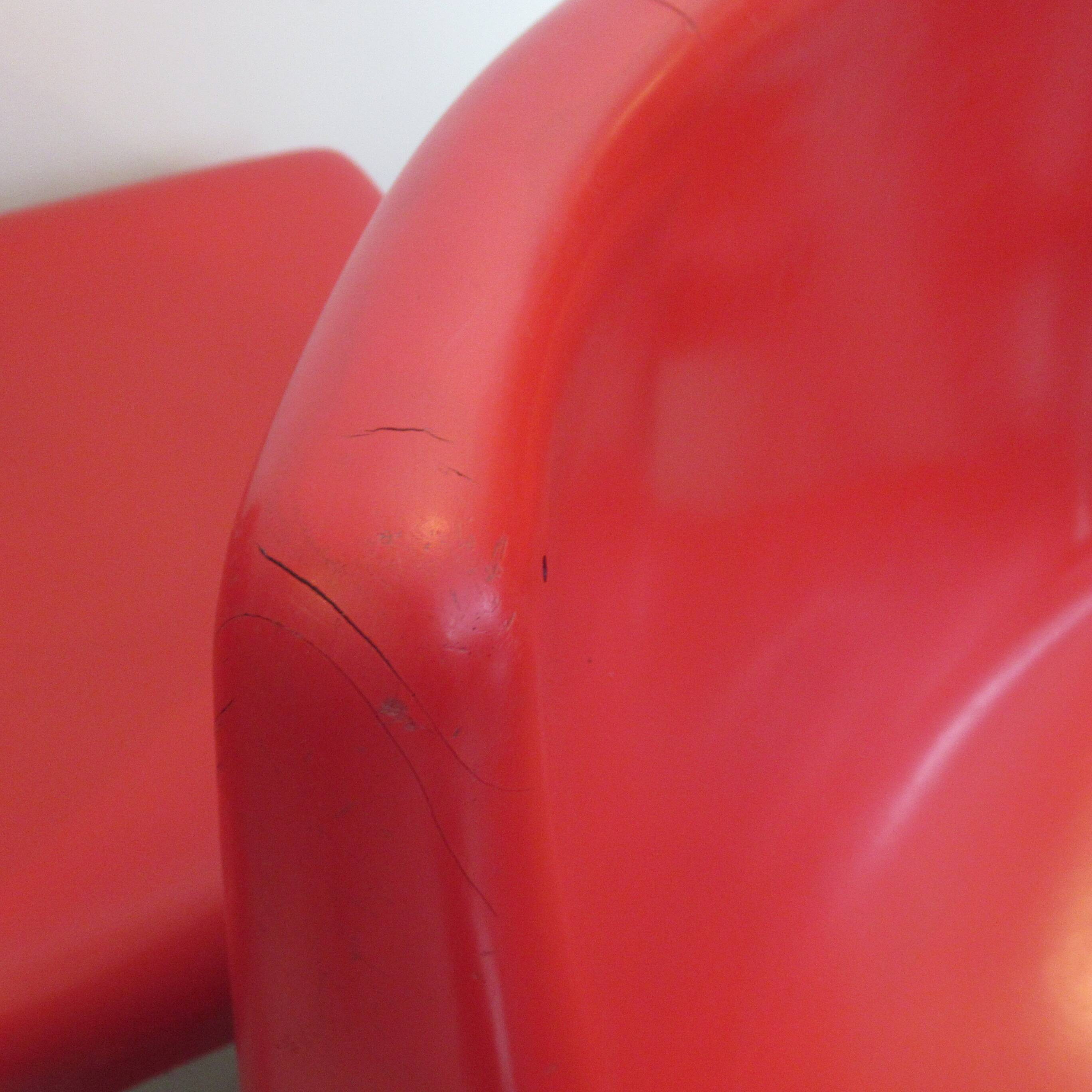 Four red fibreglass chairs from the 1970s.