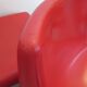 Four red fibreglass chairs from the 1970s.
