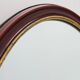 French Burgundy Lacquered Oval Mirror with Gilt Inner Edge, circa 1920