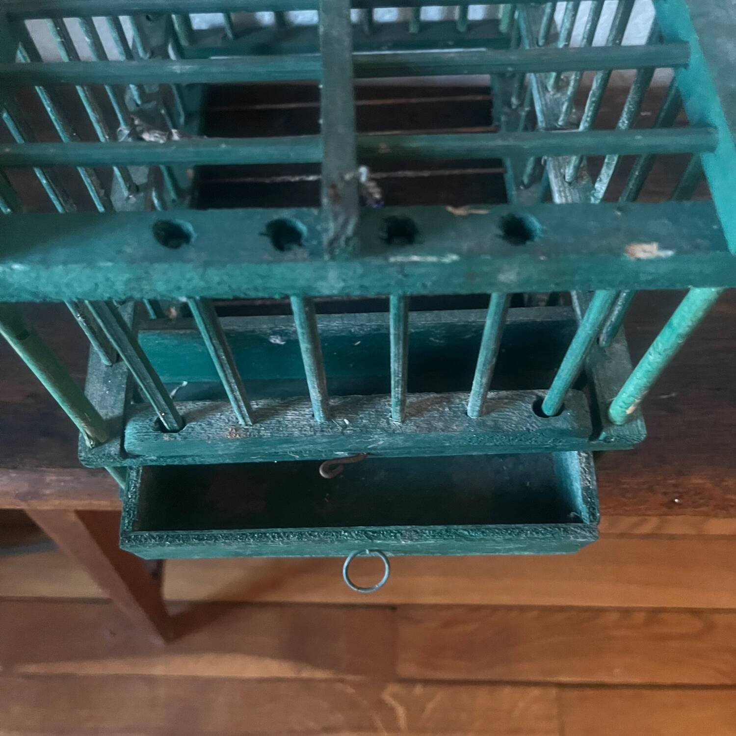 old bird cage made of wood and painted green