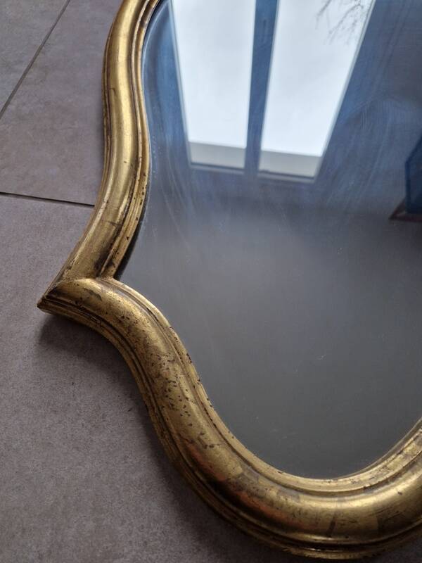 Miroir en bois doré sculpté et doré, le fronton à décor d'une coquille