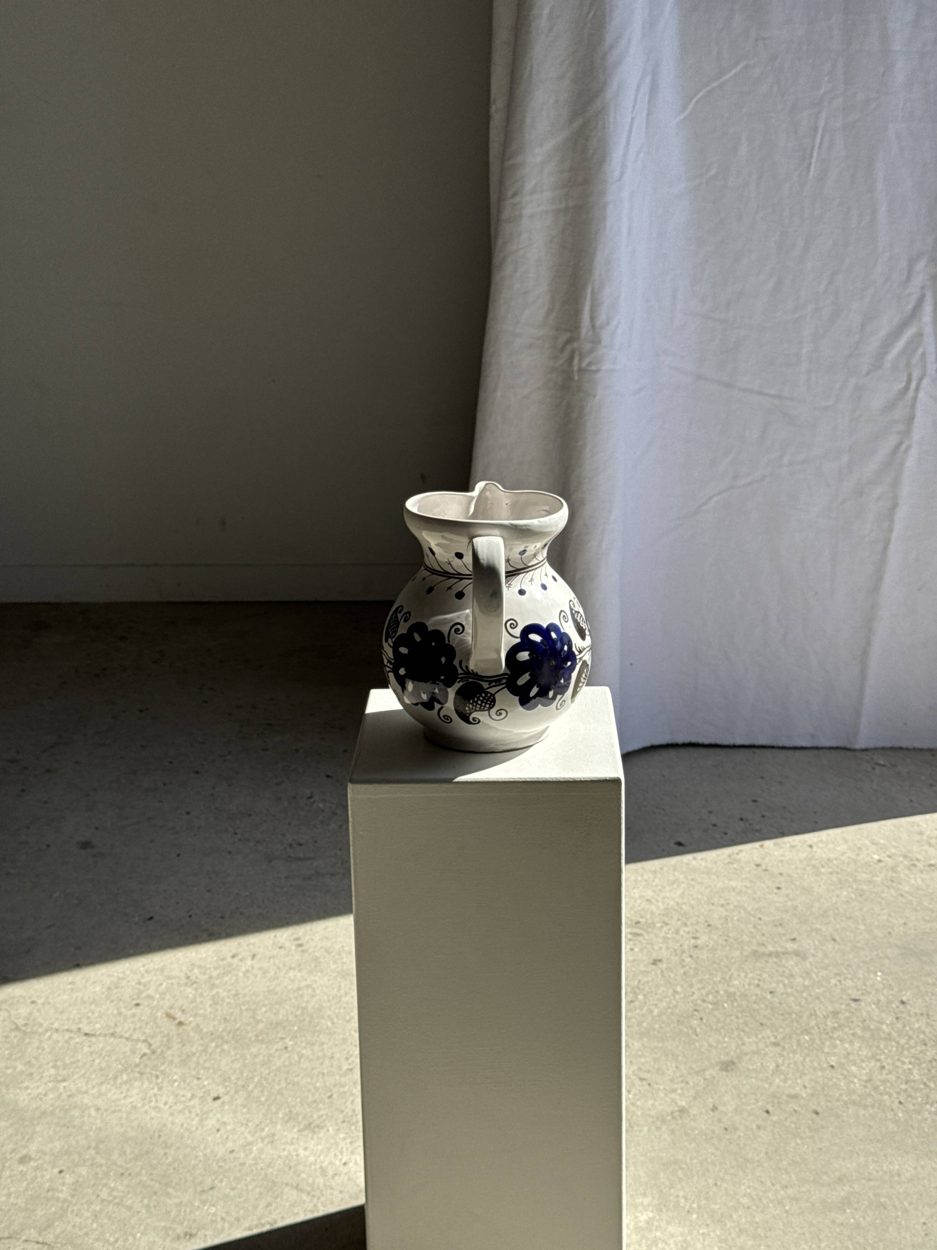 Very large vintage ceramic carafe in white glazed with blue floral decoration.