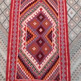 Red carpet with multicolored Berber patterns woven with hands