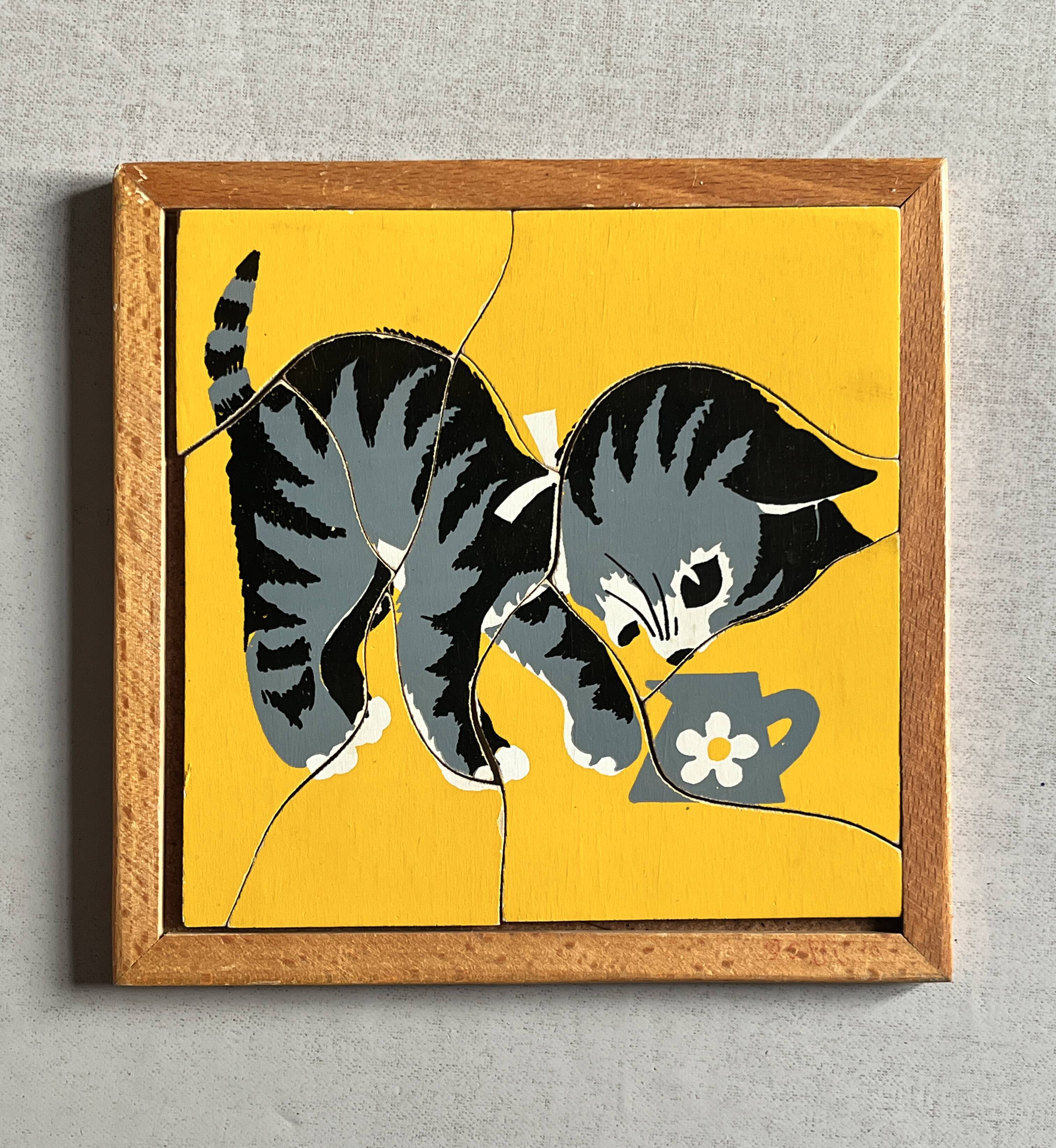 Wooden frame puzzle from the 1940s/50s depicting a cat on a yellow background.