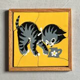 Wooden frame puzzle from the 1940s/50s depicting a cat on a yellow background.