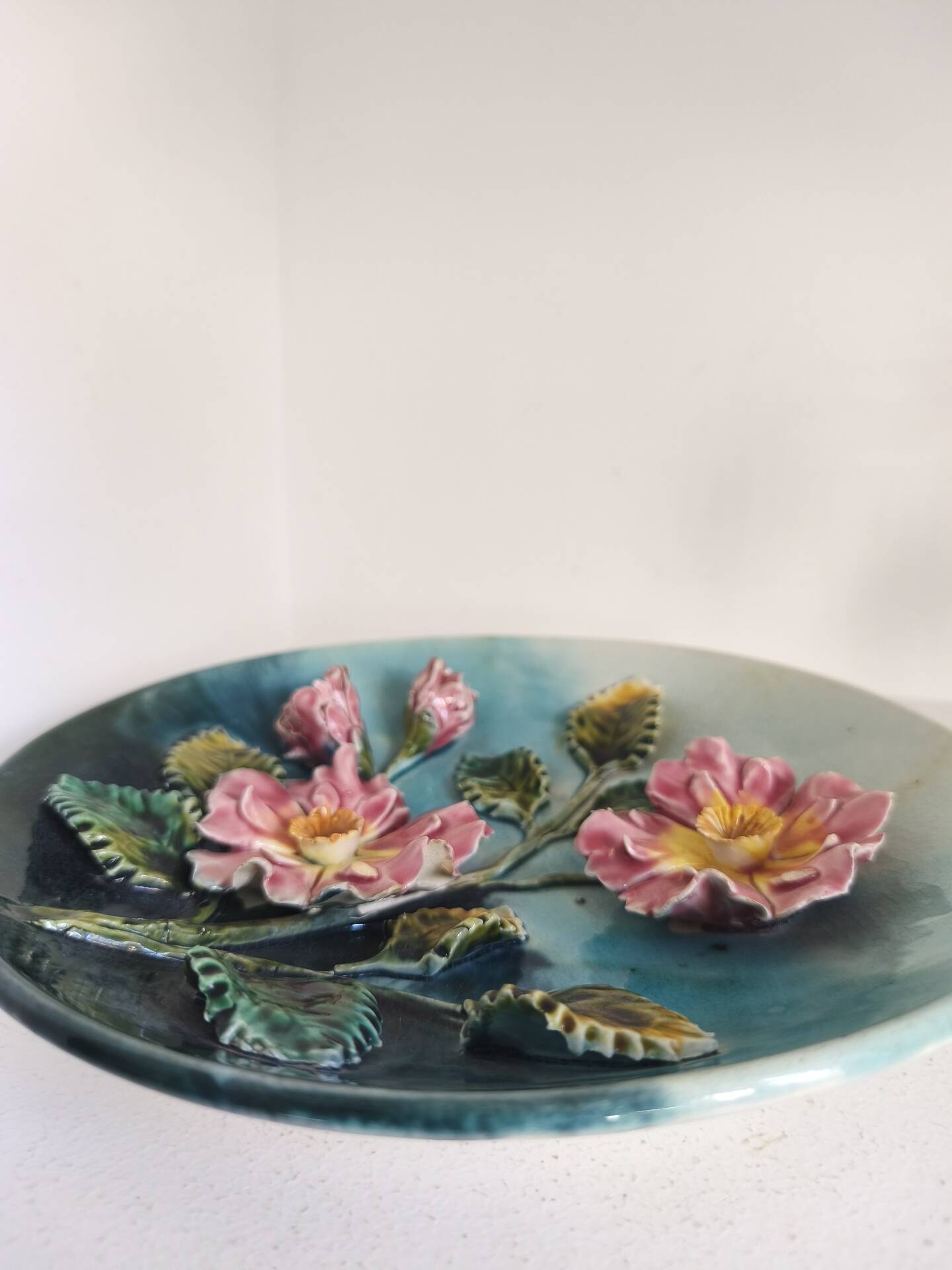 Decorative plate with relief floral pattern in majolica.