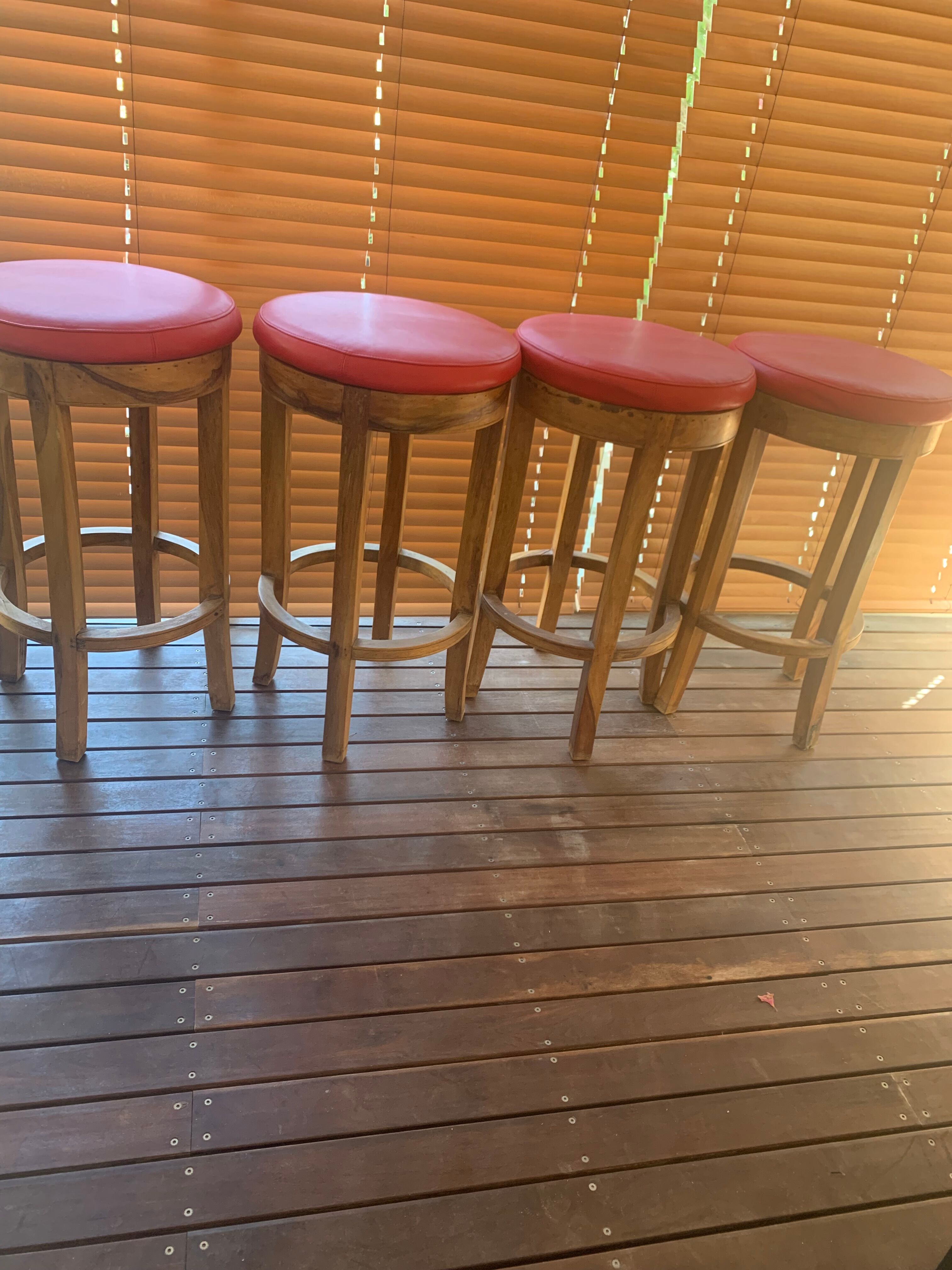 Set of 4 bar stools in solid exotic wood and red leather.