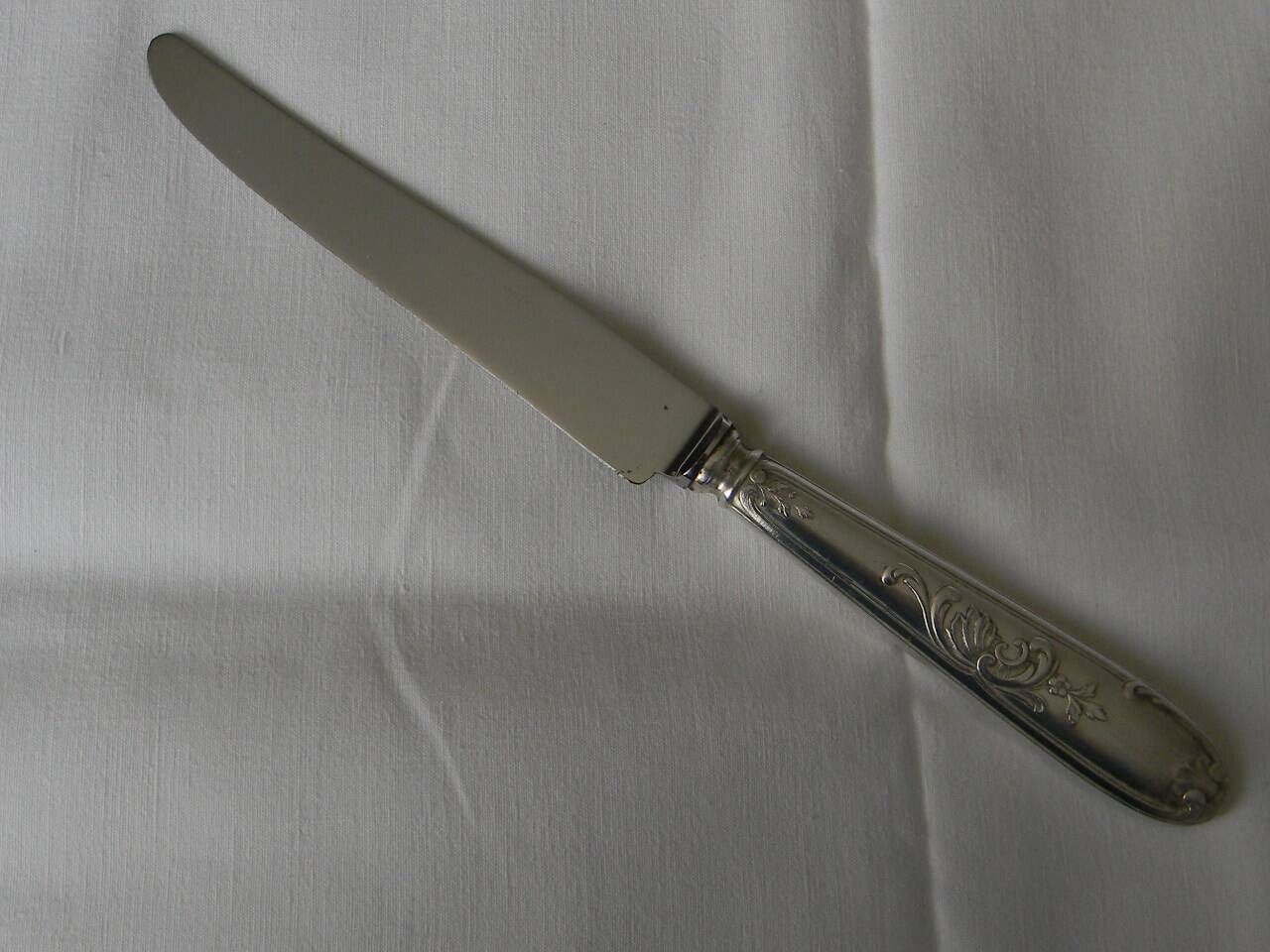 Set of 12 knives with silver metal handles and stainless steel blades.