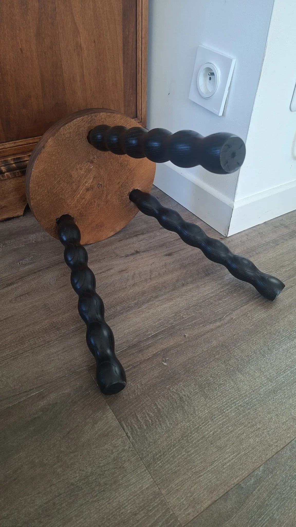 Brown and black wooden tripod stool