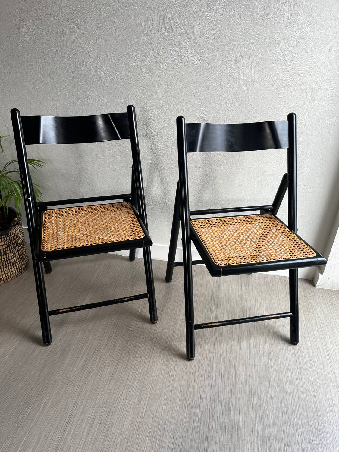 Vintage folding chairs in black wood and cane.