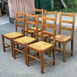 6 light solid wood chairs with high straw backs, farmhouse style.