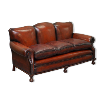 Restored Victorian sofa in leather with claw feet and feather cushions.