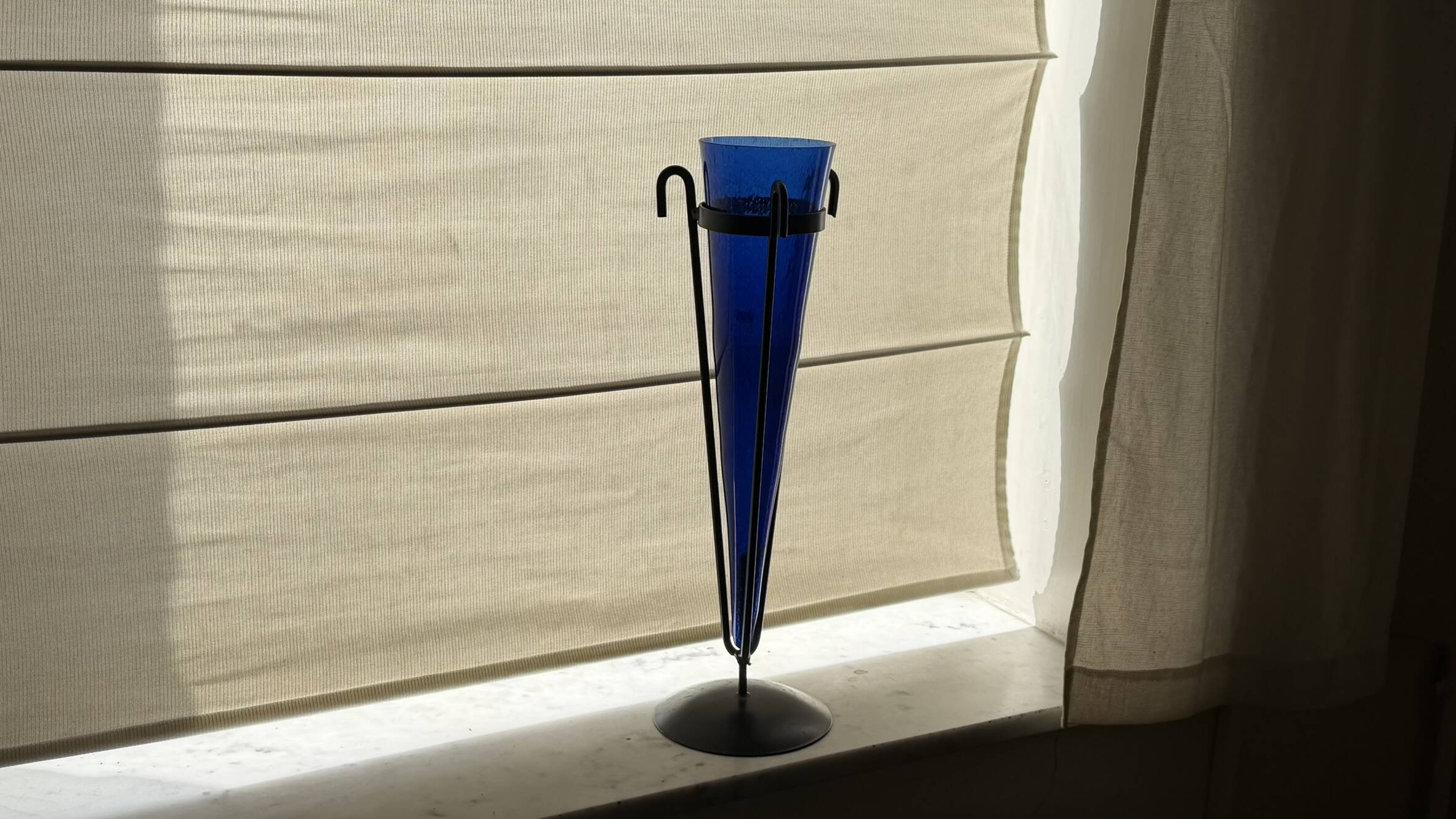 Cobalt blue vase on a metal structure.