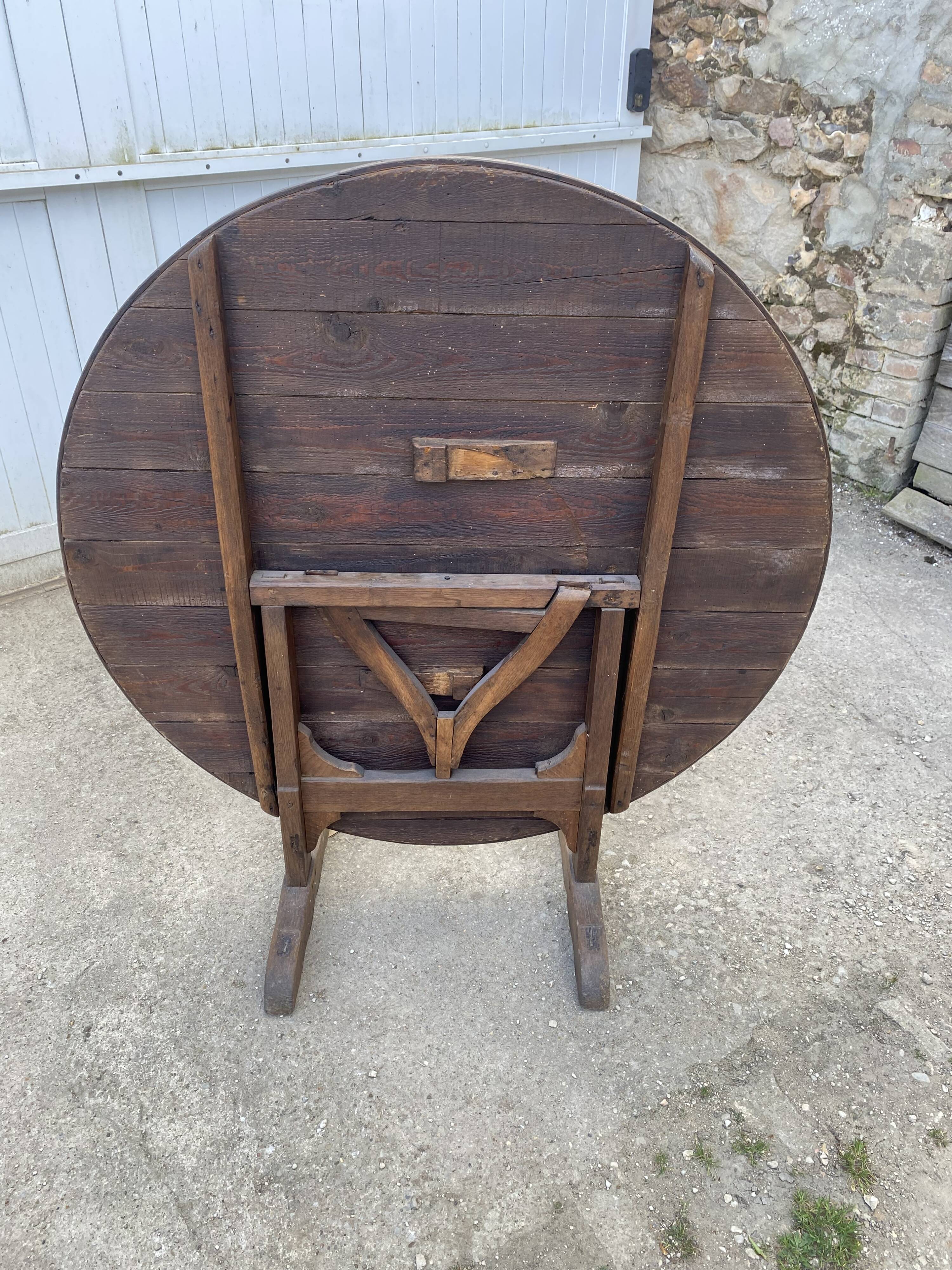 Old folding round winemaker's table with a tilting top.