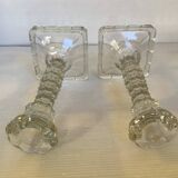 Pair of tall candle holders in the shape of a flower with a square base.