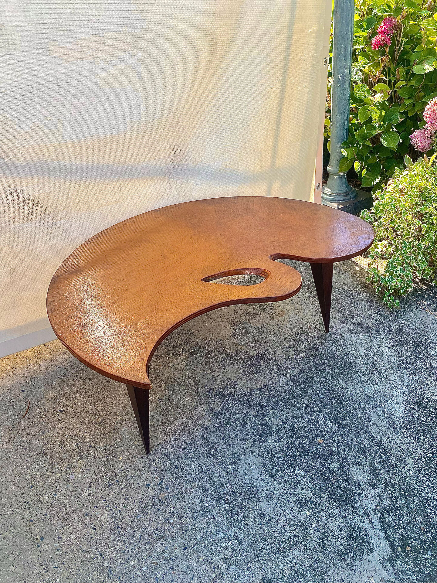 Mid-century coffee table with a palette shape and splayed legs.