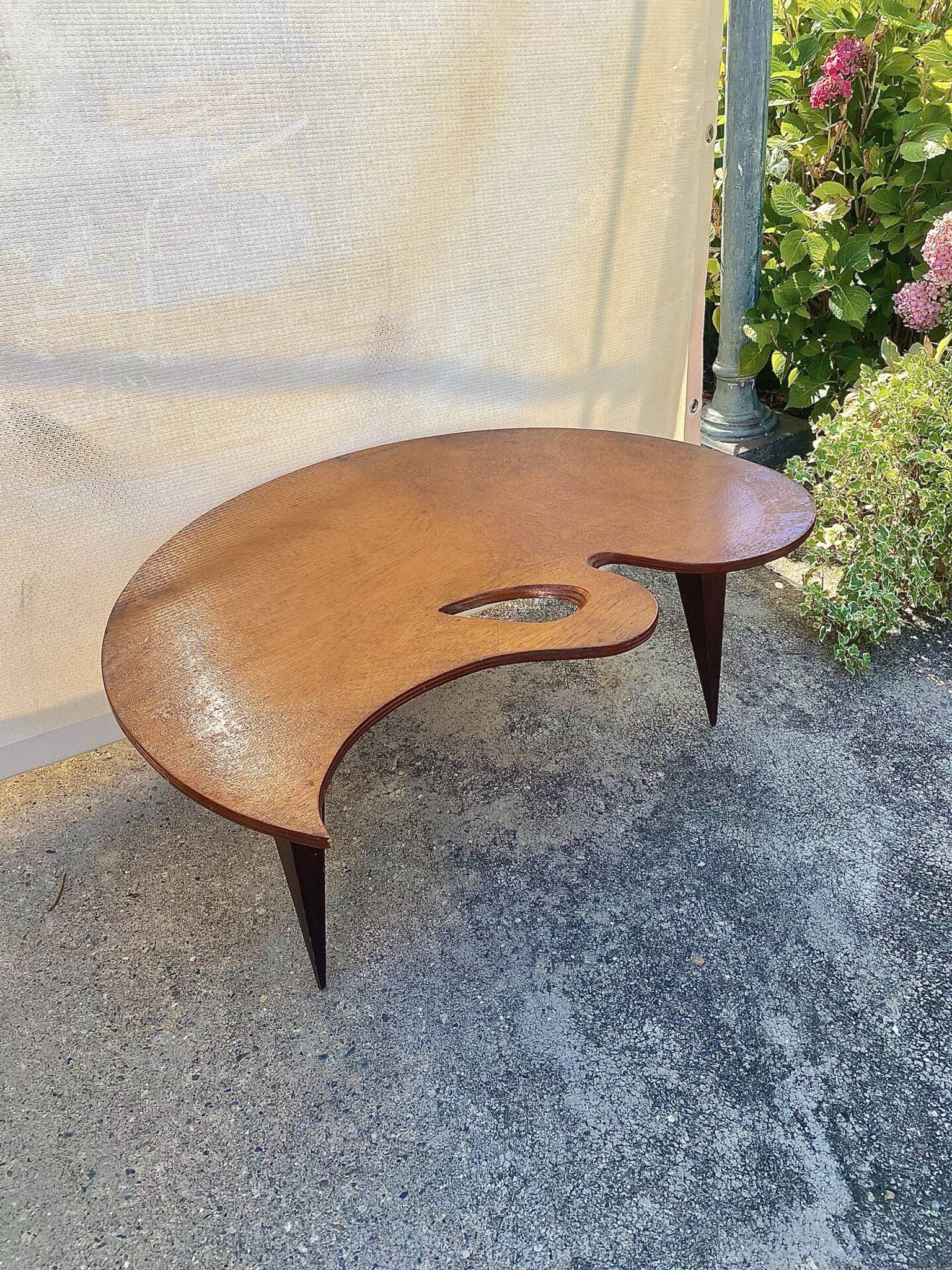 Mid-century coffee table with a palette shape and splayed legs.
