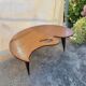Mid-century coffee table with a palette shape and splayed legs.