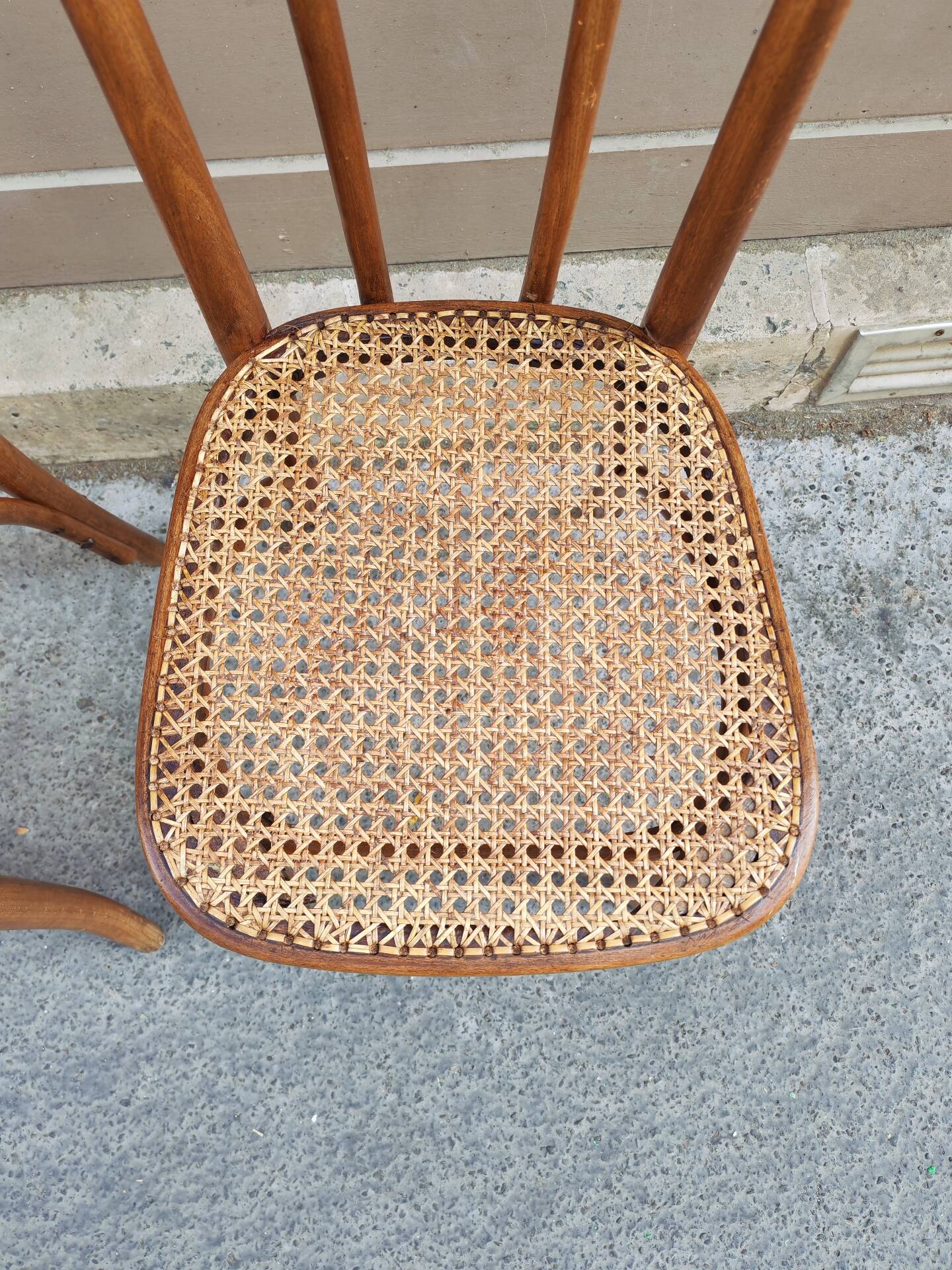 Pair of vintage bistro chairs in curved wood and caning.