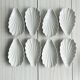 Set of white porcelain ramekins, ribbed shell shape.