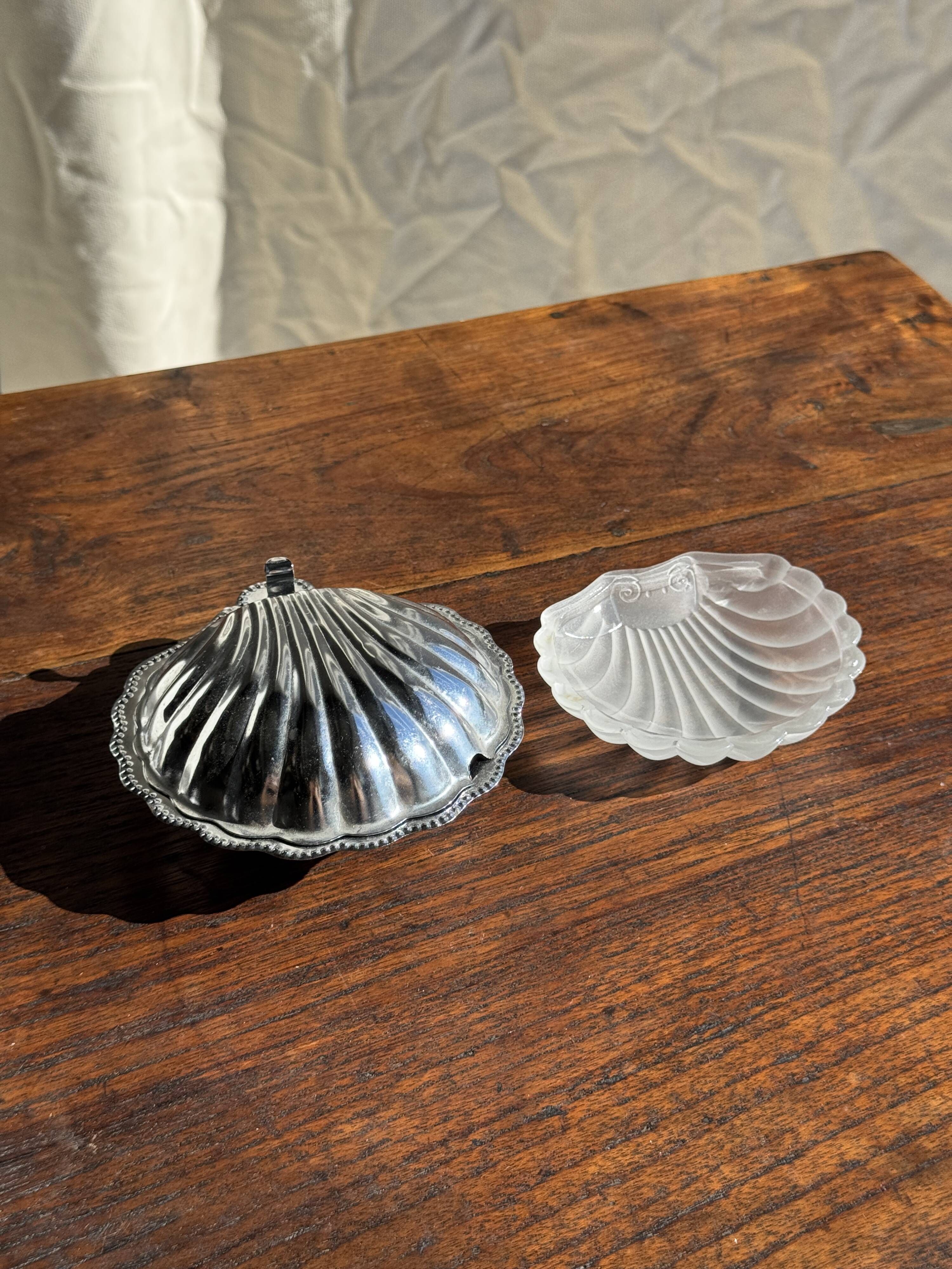 Vintage silver-plated shell butter dish with transparent bowl.