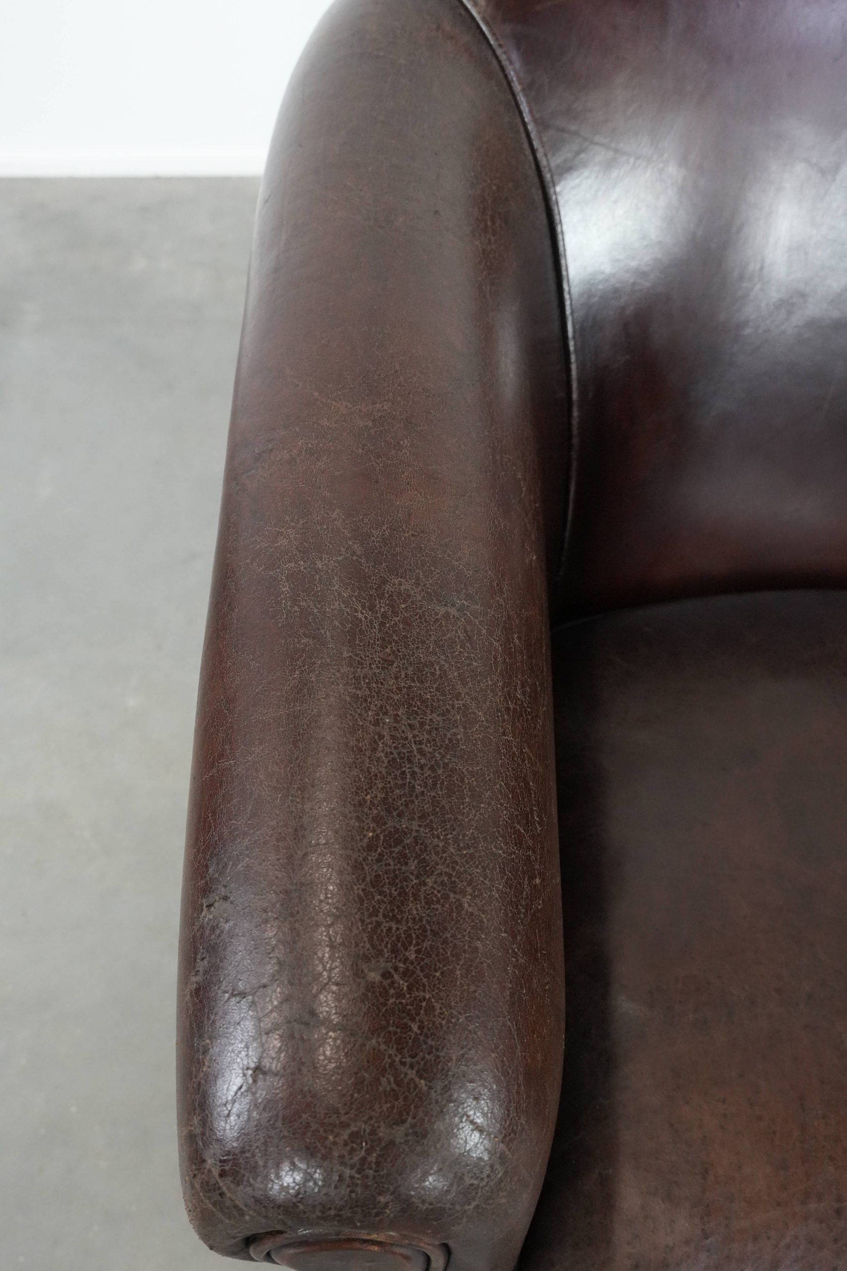 Stylish and sturdy dark brown club armchair made of sheepskin leather