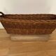 Vintage brown wicker baguette basket, elongated shape, with integrated handles.