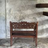 Small antique Indonesian bench in carved teak with plant and floral motifs.