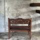 Small antique Indonesian bench in carved teak with plant and floral motifs.