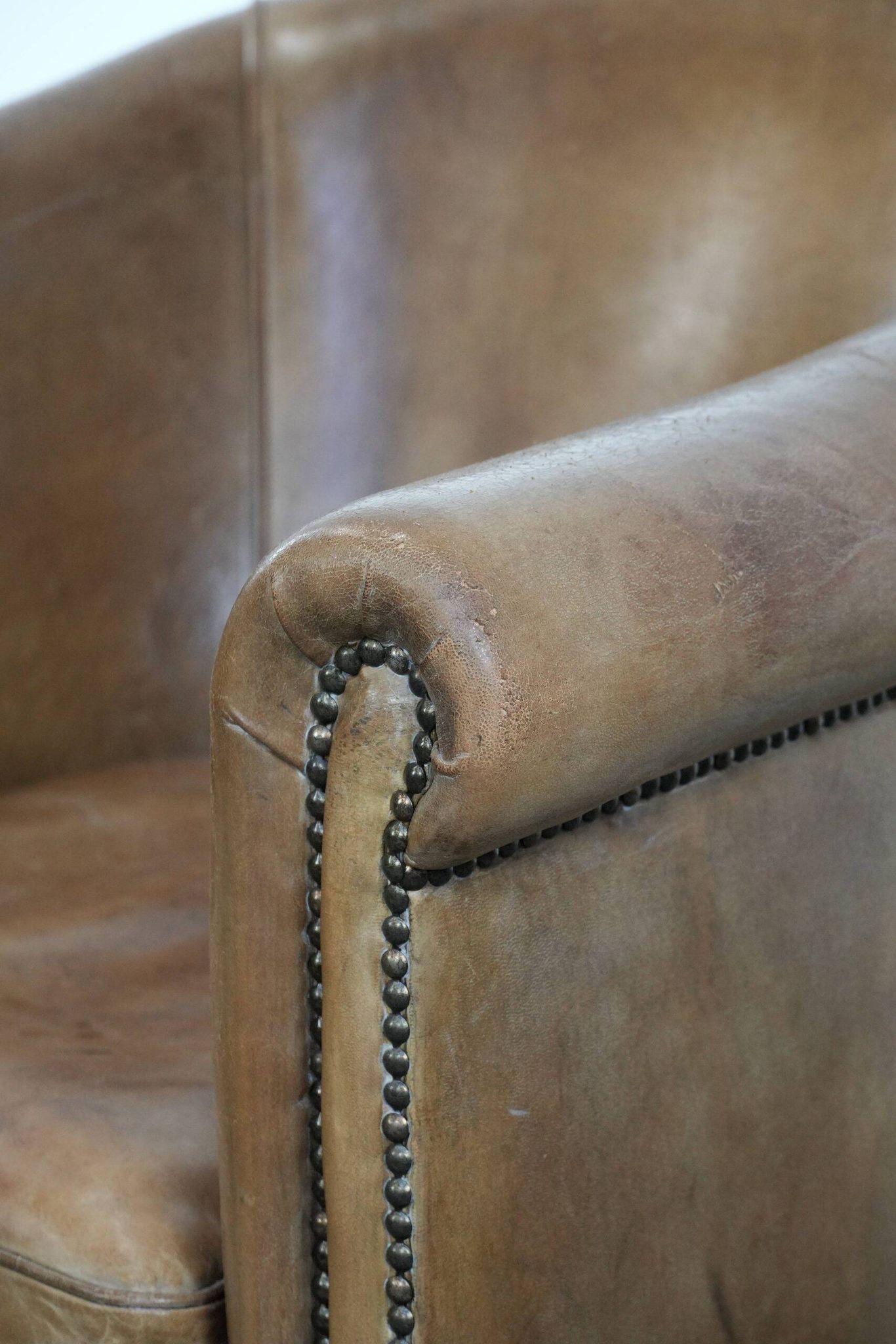 Characterful club chair made of sheepskin leather with light cognac colours