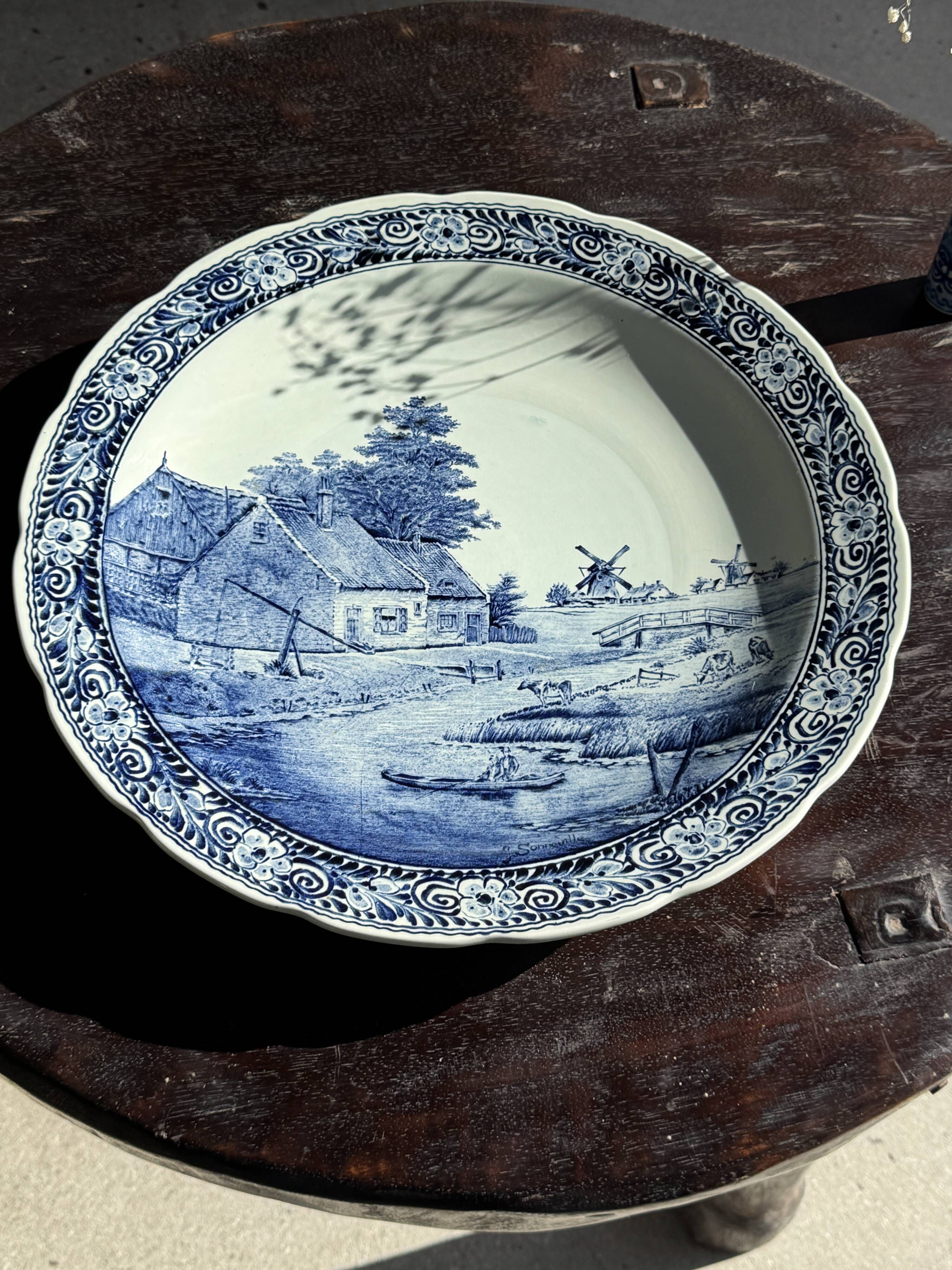 Vintage hollow circular plate in blue and white Boch pottery.