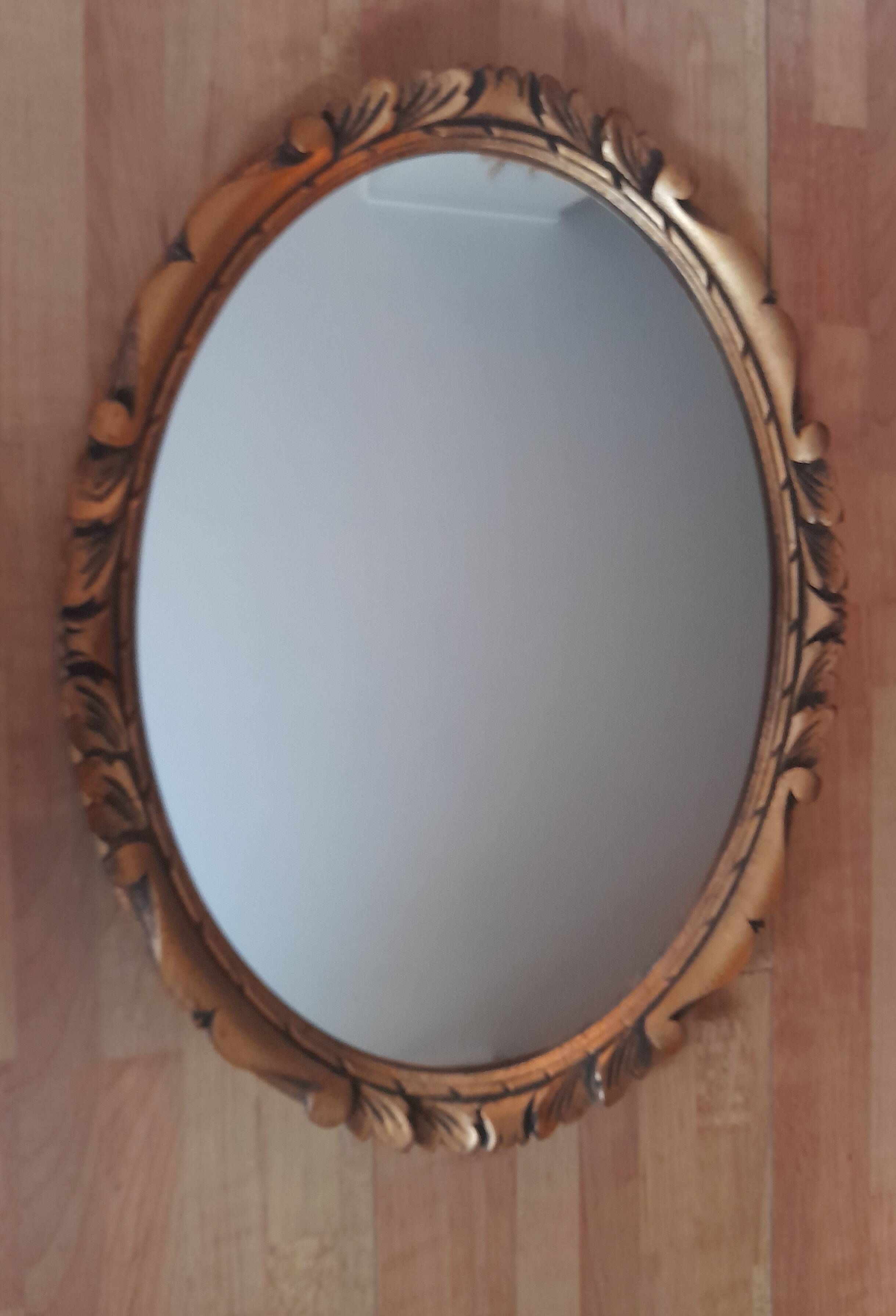 Oval wall mirror in gilded wood