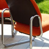 The 1970s orange armchair fabric and chrome metal
