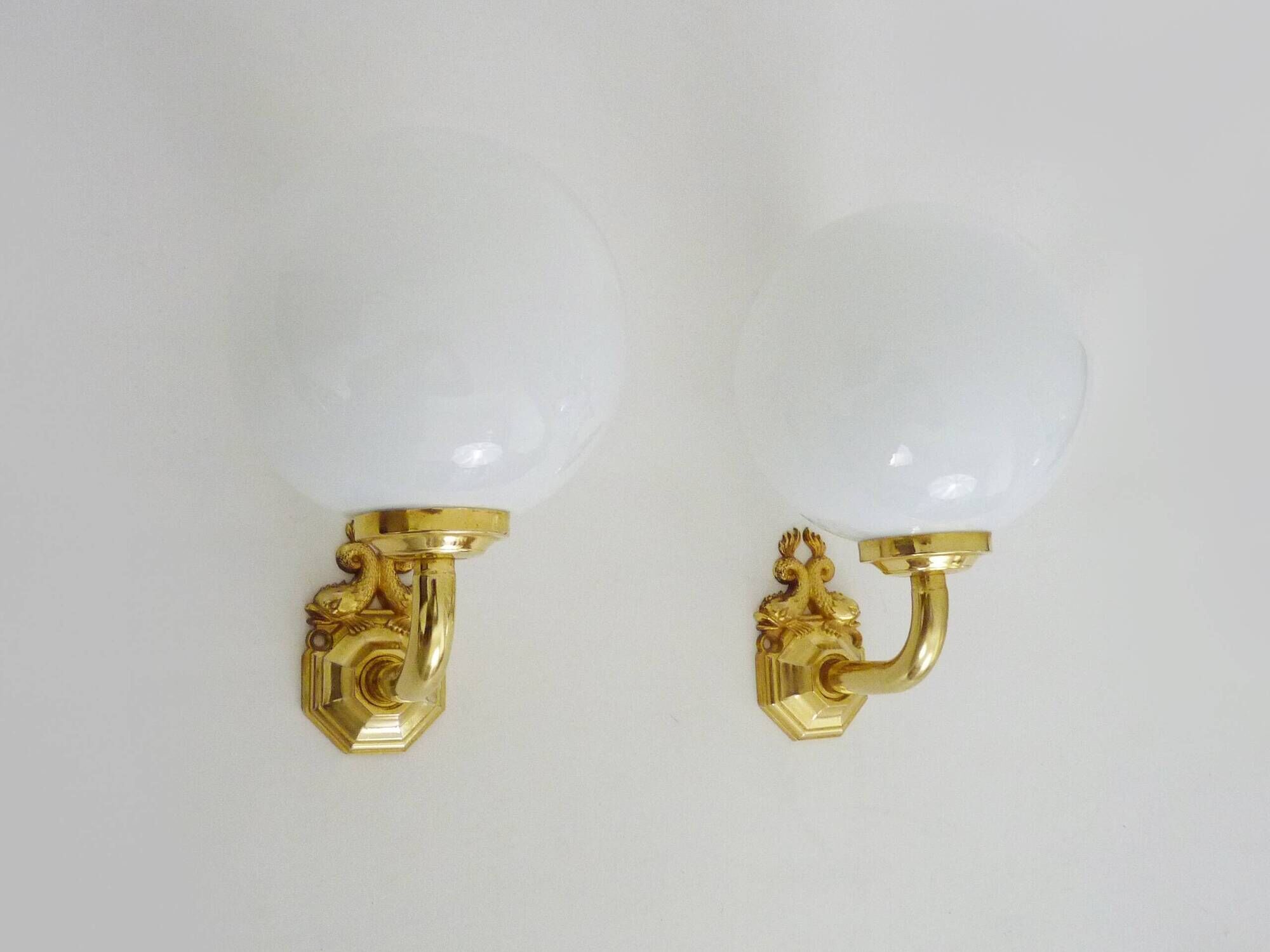 Pair of wall sconces with carp fish, brass and opaline globe.