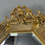 Antique octagonal mirror in richly carved gilded wood, Louis XV style.