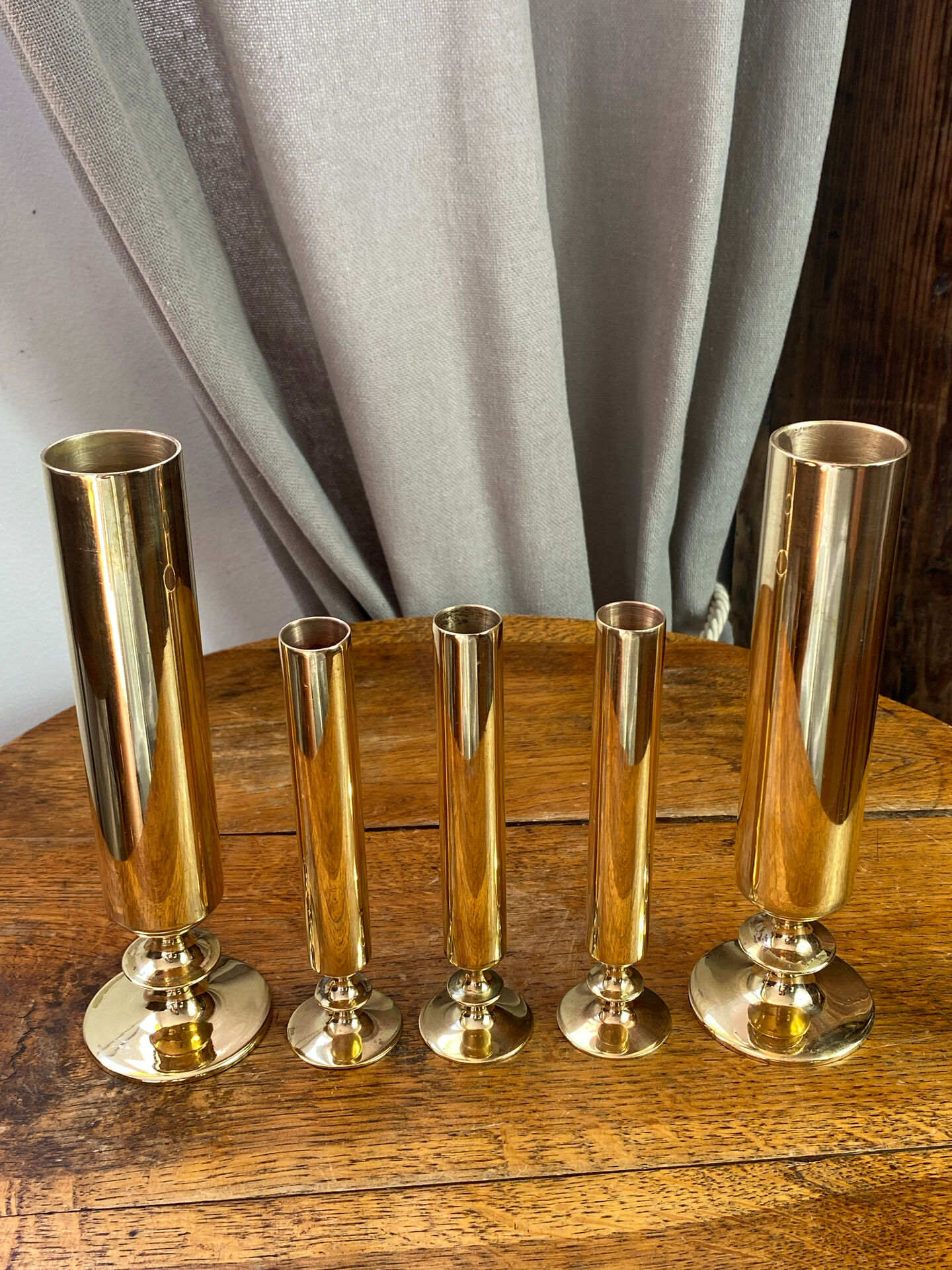 Set of candlesticks and tubular vases in solid brass.