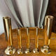 Set of candlesticks and tubular vases in solid brass.