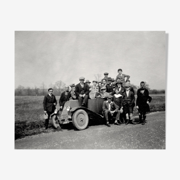 Photograph of a Renault 6CV with 23 admirers including a priest
