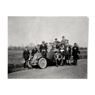 Photograph of a Renault 6CV with 23 admirers including a priest