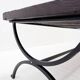Solid wood coffee table with an openwork design and wrought iron legs.